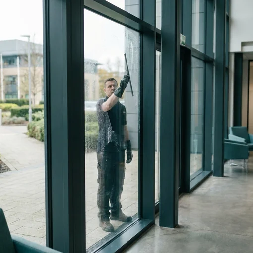 Squeegee cleaning a glass panel at commercial premises